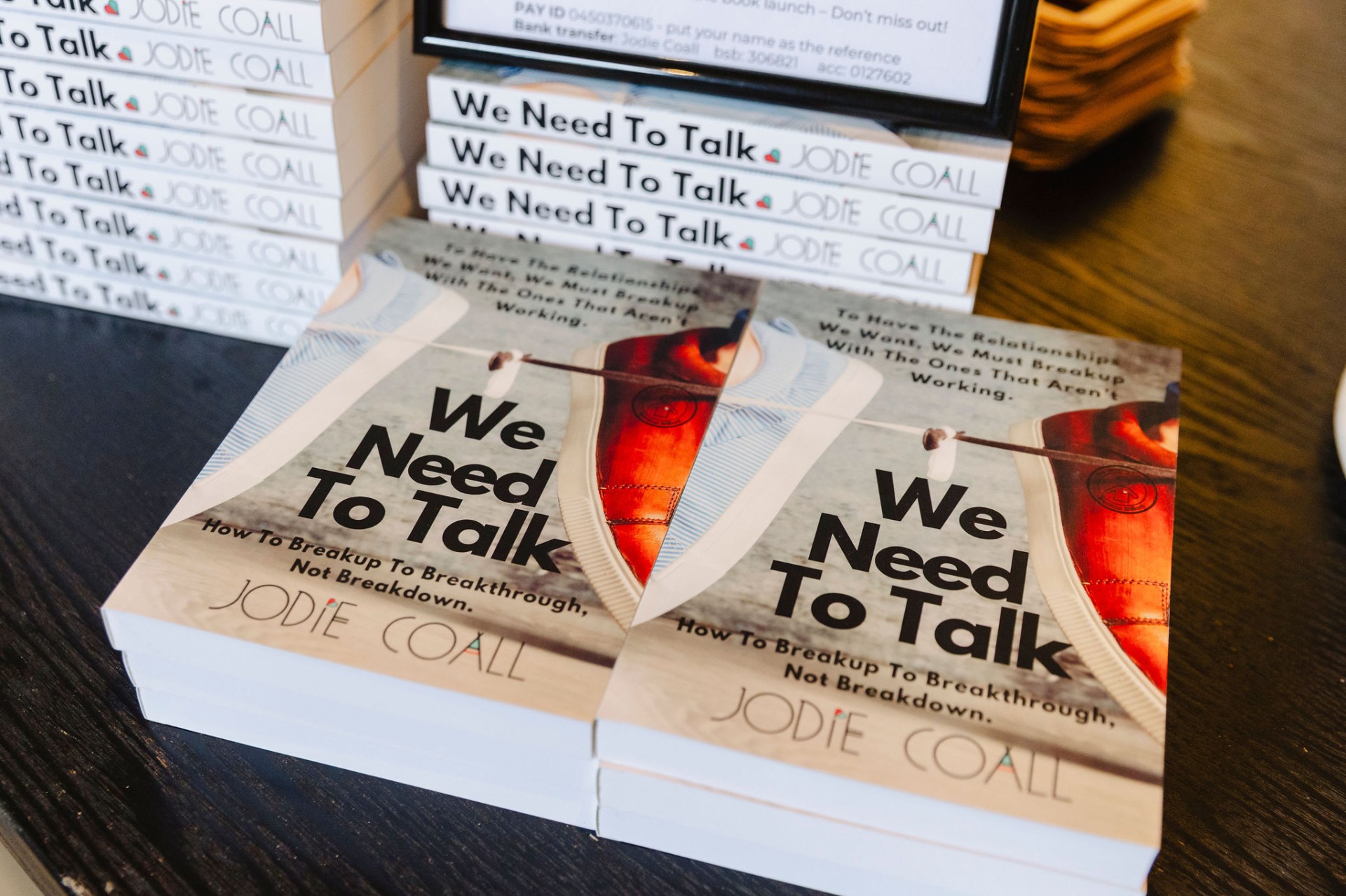 We Need To Talk by Jodie Coall, stacked copies at the book launch